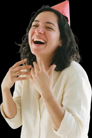 A young woman in a paper party hat laughing